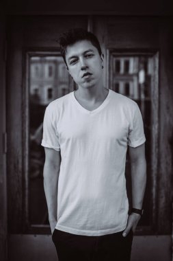 Adam binanın arka planında duruyor, kameraya bak ve etrafına bak.