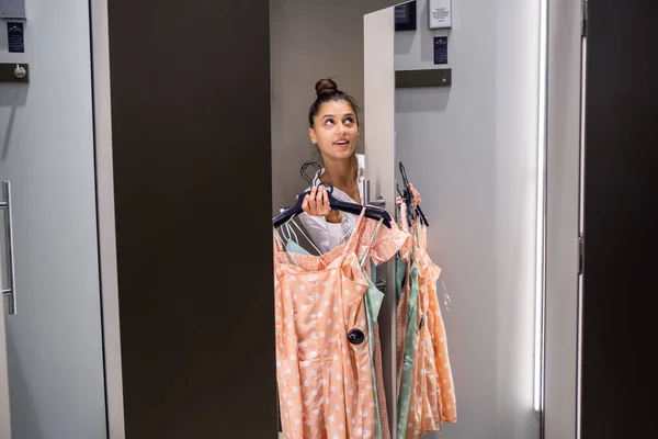 Schöne Mädchen mit viel Kleidung in Zimmer Hintergrund in einer Boutique — Stockfoto