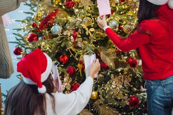 Gadis-gadis menghias pohon Natal dengan topeng pelindung. — Stok Foto