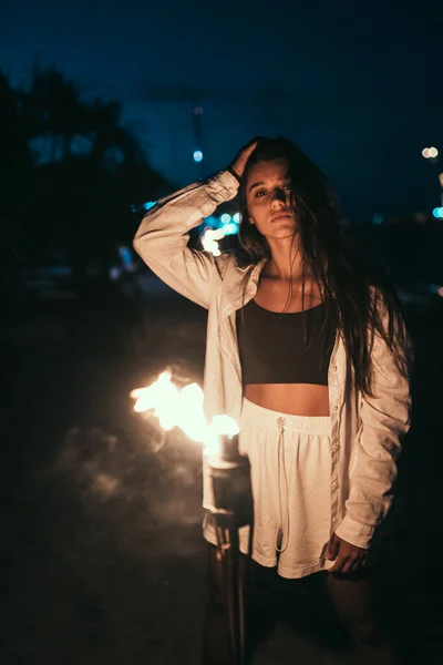 Jovem com tocha na praia à noite — Fotografia de Stock