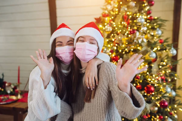 Two girls in protective masks looking at the camera and waving — Stock Photo, Image