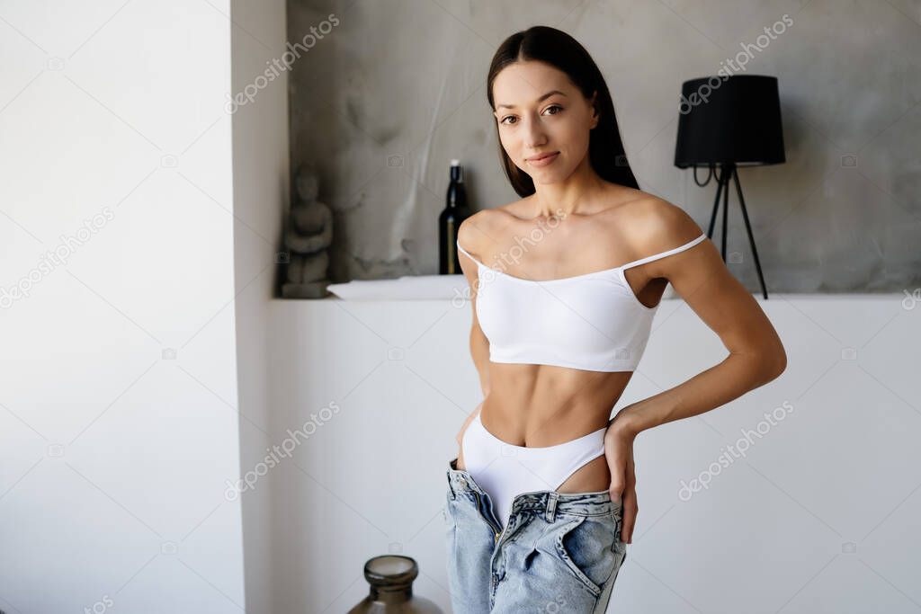 Young woman is taking her jeans off.