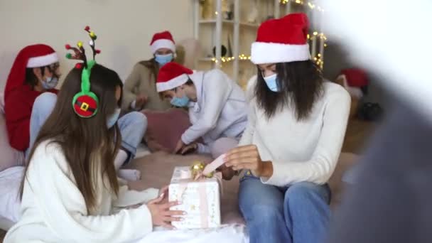 Les amis dans les chapeaux Santas changent de cadeaux à la fête de Noël — Video