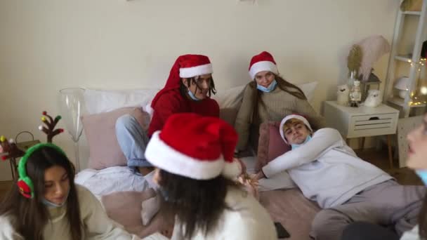 Amigos em chapéus Santas mudar presentes na festa de Natal — Vídeo de Stock