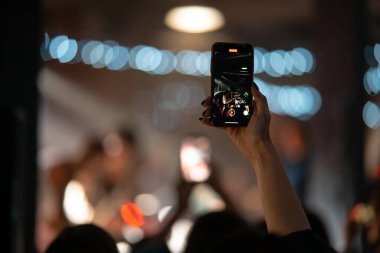 Konser sırasında akıllı telefonla video kaydını kapatan kişi.