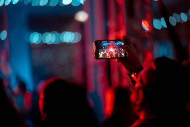Konser sırasında akıllı telefonla video kaydını kapatan kişi.