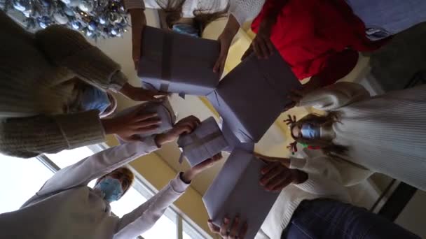 Amigos multiétnicos lanzando sus regalos de Navidad al aire. — Vídeo de stock