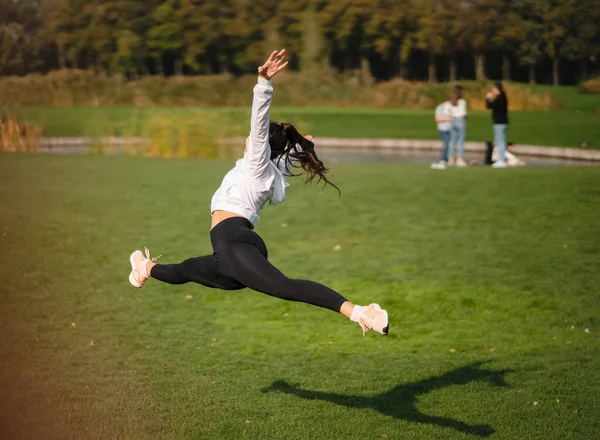 Deporte chica saltando en el aire en la naturaleza demostrar perfecto estiramiento. —  Fotos de Stock