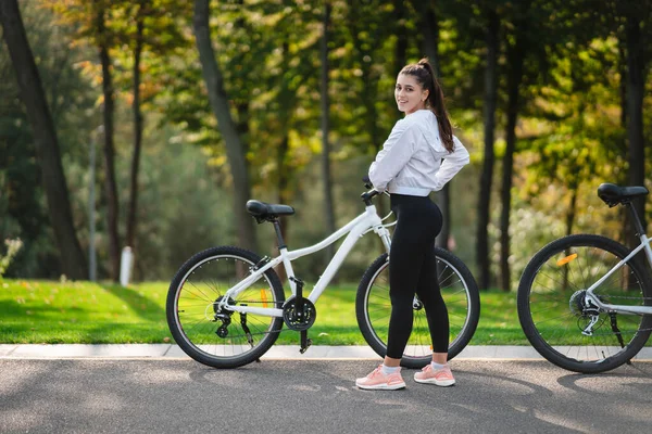 Beautiful girl posing at white bicycle. Walk in nature. — Stock Photo, Image