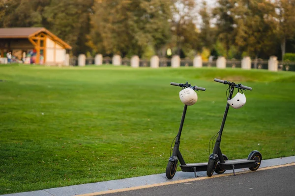 Twee elektrische kick scooters of e-scooter geparkeerd aan de zijlijn weg — Stockfoto