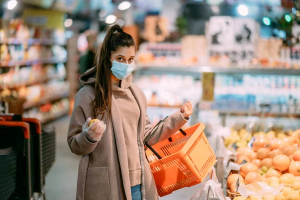 Giovane donna in maschera protettiva fa acquisti — Foto Stock