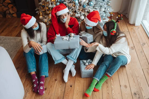 Multietnisk grupp vänner i Santa hattar med gåvor i händerna. — Stockfoto