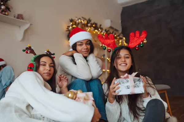 Noel Baba şapkalı, elinde hediyeler olan çok ırklı bir arkadaş grubu.. — Stok fotoğraf