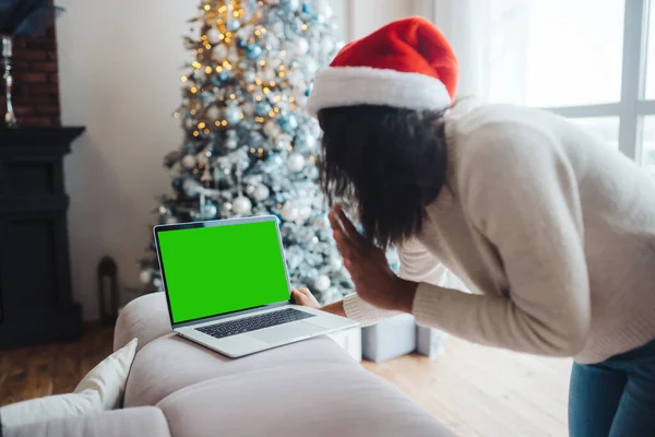 ผู้หญิงสวมหมวกซานต้าขณะพูดคุยกับเพื่อนออนไลน์บนแล็ปท็อป — ภาพถ่ายสต็อก