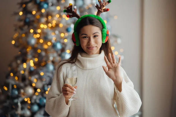 Vacker ung kvinna med ett glas champagne hemma. — Stockfoto