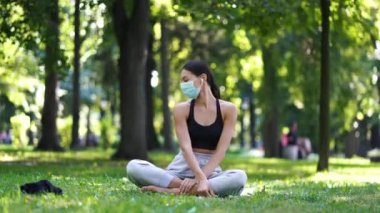 Parkta mutlu bir kadın koruyucu yüz maskesini çıkarıyor.