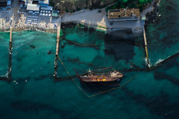 Top view of an old tanker that ran aground and overturned