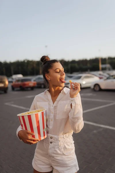 Jovem mulher bonito segurando pipocas em um shopping estacionamento — Fotografia de Stock