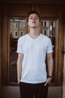 Adam binanın arka planında duruyor, kameraya bak ve etrafına bak.