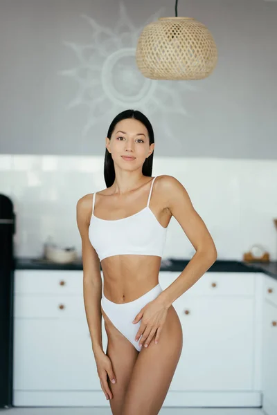 Mooi jong meisje poseren in lingerie in de keuken — Stockfoto