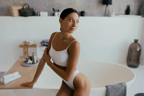 Mujer atractiva en lencería posando cerca del baño —  Fotos de Stock