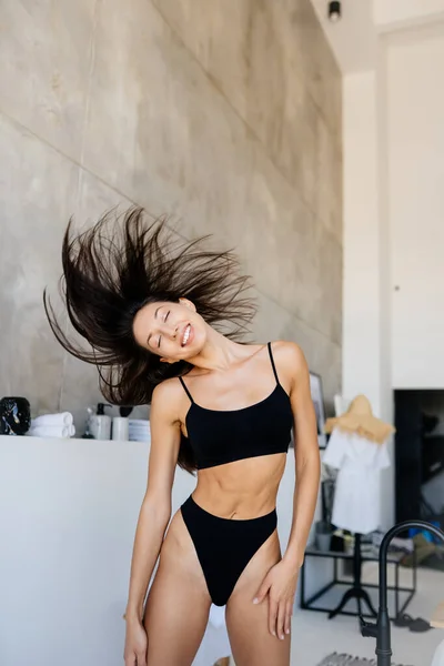 Jong aantrekkelijk meisje in zwart lingerie schudden haar hoofd met haar — Stockfoto