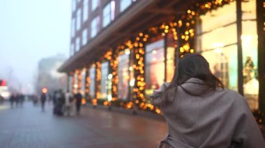 Şehir caddesinde aydınlatılmış bir gösteri yapan kadın..