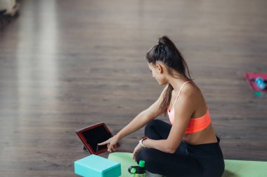 Yoga yapan genç bir kadın internetteki öğretmenle meşgul..