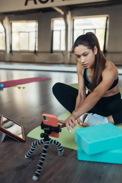 Mujer joven practicando yoga, está comprometida con el profesor en línea. — Foto de Stock