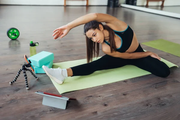 Mujer joven practicando yoga, está comprometida con el profesor en línea. — Foto de Stock