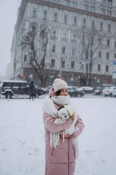 3.女孩子怀里抱着狗，雪下得很大 — 图库照片