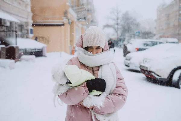 Flicka med en hund i famnen, snön faller — Stockfoto