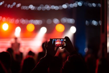 Konser sırasında akıllı telefonla video kaydını kapatan kişi.