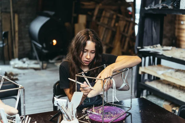 Портрет молодої жінки, яка насолоджується улюбленою роботою в майстерні . — стокове фото