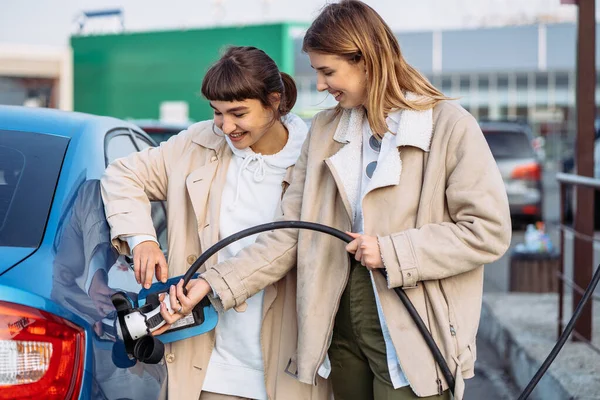 Glückliche Freunde tanken Auto an Tankstelle. Urlaubsreise — Stockfoto