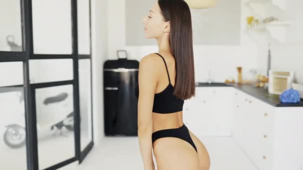Vacker ung flicka poserar i underkläder i vardagsrummet — Stockvideo