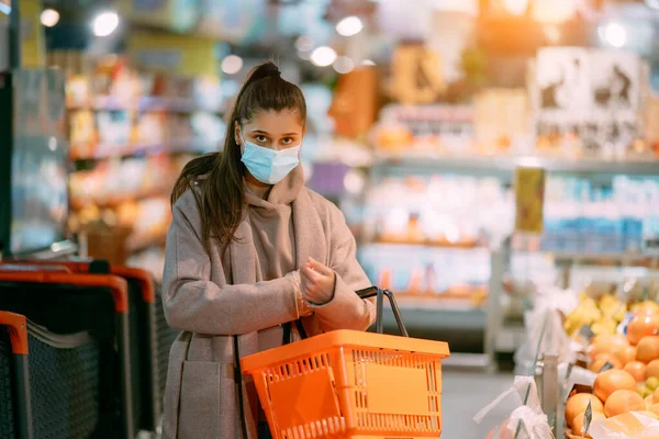 Mujer joven en máscara protectora hace compras —  Fotos de Stock