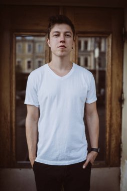 Adam binanın arka planında duruyor, kameraya bak ve etrafına bak.