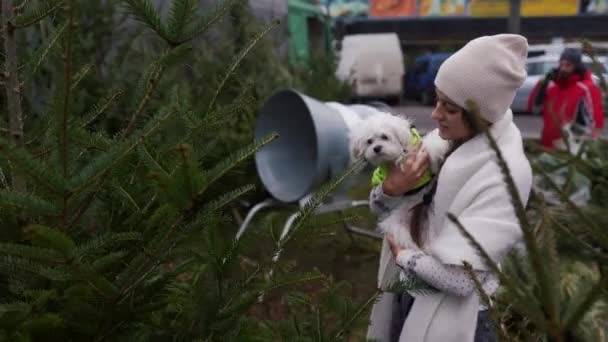 在绿树旁抱着一只白狗的女人 — 图库视频影像