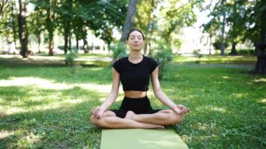 Atletik genç kadın sabahları parkta yoga yapıyor..