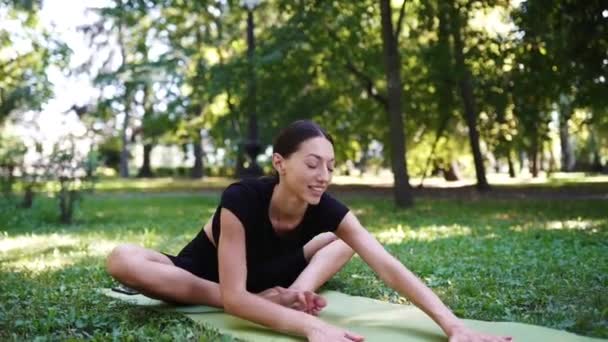 Jeune femme sportive faisant du yoga dans le parc le matin. — Video
