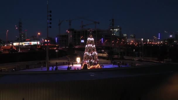 As pessoas patinam na pista em torno da árvore de Ano Novo — Vídeo de Stock