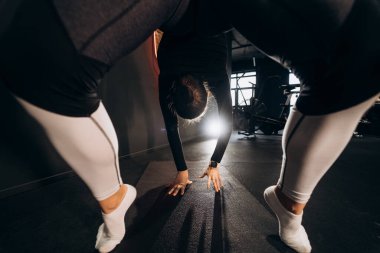 Spor salonunda briç oynayan zayıf atletik bir kadın.