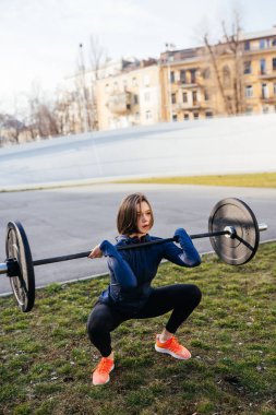Güçlü bir kadın halterle egzersiz yapıyor. Spor, spor konsepti.