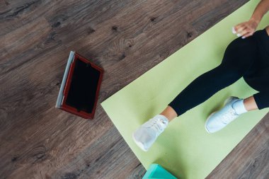 Yoga yapan genç bir kadın internetteki öğretmenle meşgul..