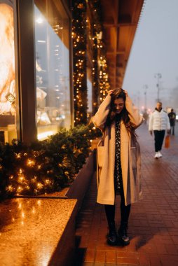 Şehir caddesinde aydınlatılmış bir gösteri yapan kadın..