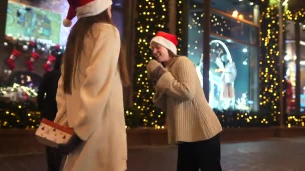 Flickan ger en gåva till sin kvinnliga vän på gatan. — Stockvideo