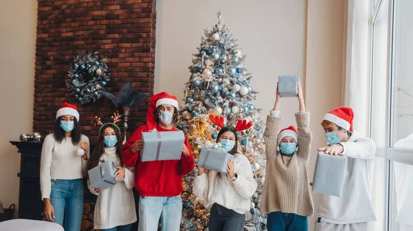 Multietnisk grupp vänner i Santa hattar med gåvor i händerna. — Stockfoto