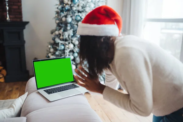 Perempuan mengenakan topi santa saat berbicara dengan teman online di laptop — Stok Foto