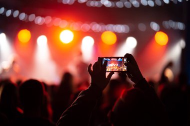 Konser sırasında akıllı telefonla video kaydını kapatan kişi.